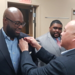 President Mark Elzy pinning a new inductee.